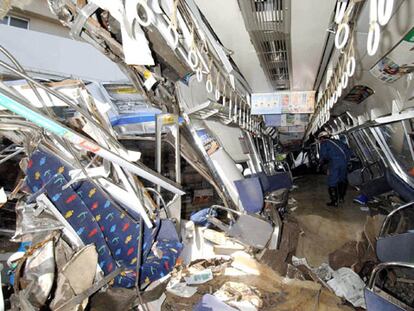 Un trabajador examina uno de los vagones destrozados del tren que descarriló en Amagasaki, al oeste de Japón.