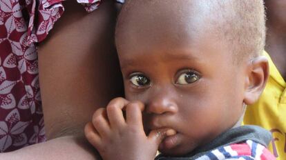 Mamadou Bâ, de 20 meses, se agarra al brazo de su madre. El pequeño sufrió malnutrición cuando solo tenía nueve meses y ahora ha vuelto a recaer. Su madre, Fatoumata Bâ, trata de sacar adelante a sus ocho hijos con los pocos ingresos que le reporta la venta de telas. Su padre, Seydou Bâ, pasa la mayor parte del año pastoreando el ganado, cabras y corderos, en lugares cada vez más alejados.