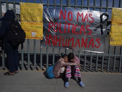 Dos mujeres venezolanas se consuelan sentadas frente a un centro de detención de inmigrantes en Ciudad Juárez.