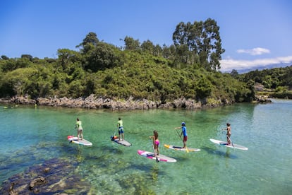 Jóvenes practicando surf con remo en la ría de Barru.