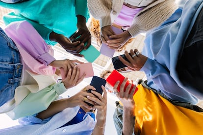 Un grupo de jóvenes sosteniendo teléfonos móviles.
