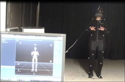 Un sujeto con un casco de realidad virtual y un sistema de monitorización corporal durante un experimento de 'embodiment'