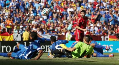 David Villa observa el balón que pasa ante varios jugadores de El Salvador que permanecen en el suelo.