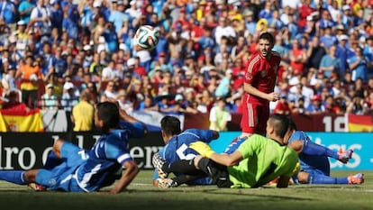 David Villa observa el balón que pasa ante varios jugadores de El Salvador que permanecen en el suelo.