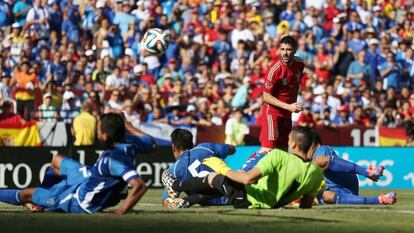 David Villa observa el balón que pasa ante varios jugadores de El Salvador que permanecen en el suelo.