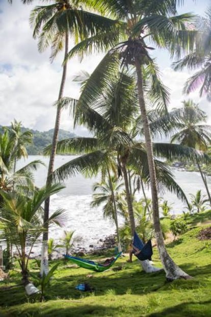 Dos jóvenes descansan en sendas hamacas frente al mar caribe.