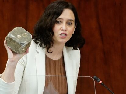 La presidenta de la Comunidad de Madrid, Isabel Díaz Ayuso, muestra un adoquín en la Asamblea de Madrid el pasado febrero.