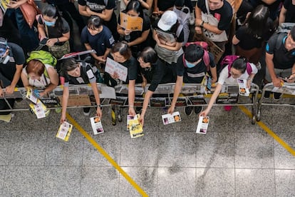 Los manifestantes reparten folletos en la sala de llegadas del aeropuerto de Hong Kong, el 11 de agosto de 2019.