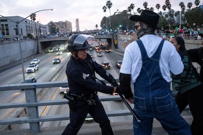 Agentes de policía chocan con manifestantes durante una manifestación contra las detenciones y deportaciones de migrantes en Los Ángeles.