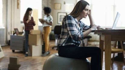 A woman seated on a fitball, which is recommended by physiotherapists.