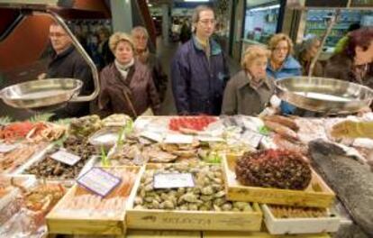 Un grupo de personas hacen cola ante una pescadería en el Mercado de Vitoria. EFE/Archivo