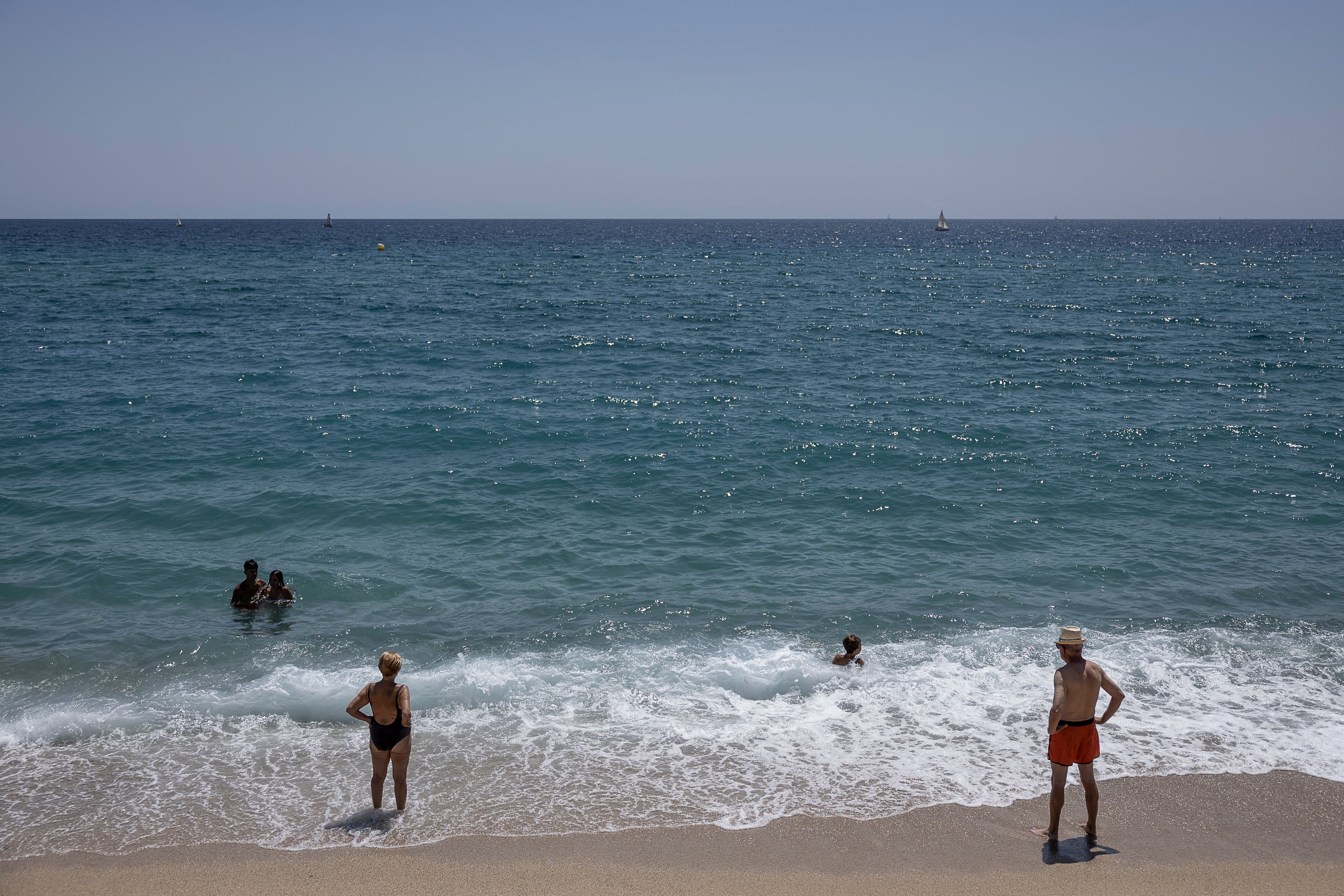 Socorristas vigilan a bañistas en la playa de Badalona en foto de archivo.