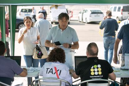 Un taxista entrega su papeleta en una de las mesas colocadas en el aparcamiento del estadio Civitas Metropolitano para el referéndum. 
