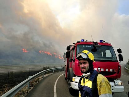 Un efectivo del cuerpo de bomberos observa en la AP-7 las llamas del incendio forestal declarado hacia las 13 horas en La Jonquera (Girona).