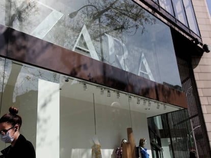 Una mujer con mascarilla pasa junto al escaparate de la tienda Zara de la Calle Princesa de Madrid del grupo Inditex.