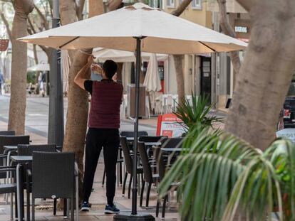 Un camarero coloca una sombrilla en la terraza de un bar en la calle Betenchourt Alfonso de Santa Cruz de Tenerife. EFE/Miguel Barreto/Archivo