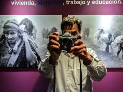 El fotógrafo José Rodríguez posa frente a imágenes de desplazados.