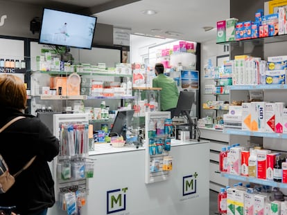Una mujer espera a ser atendida en una farmacia.