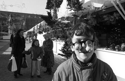 Un niño con unas gafas de broma, en el mercadillo de la Plaza Mayor, el 7 de diciembre de 1988. Decía el maestro Joaquín Vidal en su crónica <a href=https://elpais.com/diario/1989/01/07/ultima/600130802_850215.html>'El día después:'</a>, "Nadie sabe qué quiere de verdad un niño para Reyes hasta el día después". "Desde tiempo inmemorial, millones de familias se vienen asombrando de que Cuquita prefiera su muñeca pelona a la sofisticada que le traen los Reyes Magos. Si los adultos no perdieran memoria de su niñez, se asombrarían menos". Sobre que los niños tuvieran que volver al cole al día siguiente, según don Joaquín: "Un caso de crueldad mental".