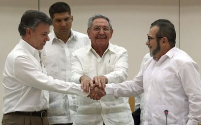 Juan Manuel Santos y Rodrigo Londoño, 'Timochenko', se dan la mano en La Habana junto a Raúl Castro, en septiembre de 2019.