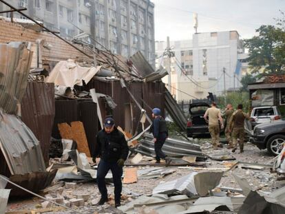 A police officer and a rescue worker walk in front of a restaurant RIA Pizza destroyed by a Russian attack in Kramatorsk, Ukraine, on June 27, 2023.