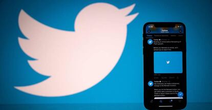Logo de Twitter junto a un móvil con la aplicación funcionando.