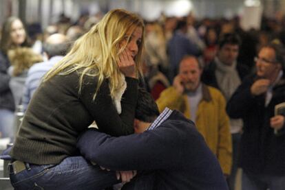 Una pareja refleja su desconsuelo tras sufrir los retrasos y cancelaciones en el aeropuerto de Barajas.