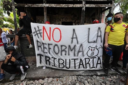 En imágen, manifestantes sostienen un cartel en Cali, Colombia.