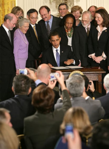 Obama firma, rodeado de científicos, la orden que reanuda la investigación pública con células madre.