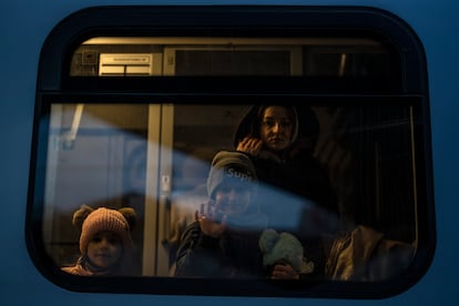 Una familia ucrania saluda desde un tren que va a Varsovia, en la estación de tren de Przemysl, Polonia, el jueves 10 de marzo de 2022.