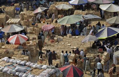 Compradores y vendedores paquistaníes se reúnen en un mercado de frutas en Lahore (Pakistán).