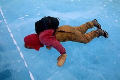 Un viajero mira a través del hielo en Mummy Pond, en la Antártida.