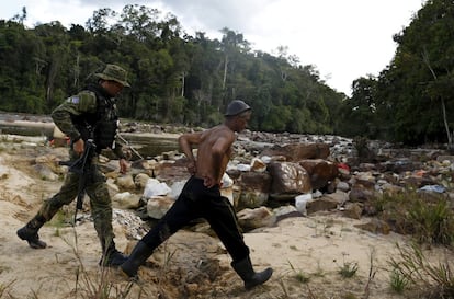 Un agente de la Agencia ambiental de Brasil detiene a un hombre en una mina de oro ilegal durante una operación contra la minería ilegal en tierras indígenas, en el corazón de la selva amazónica.