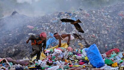 Dos jóvenes buscan objetos reciclables en un vertedero de Jammu (India).