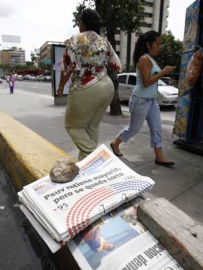 Transeúntes caminan junto a periódicos en una calle de Caracas (Venezuela). La Cadena Capriles ha vendido todos sus mendios a un grupo inversor de este país. EFE/Archivo