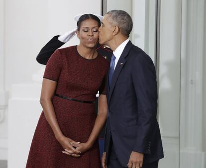 Barack Obama beija a esposa Michelle Obama, enquanto esperam aos Trump.