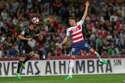 El jugador de Real Madrid James cabecea el balón cuando el delantero Juan Antonio lo acosa.