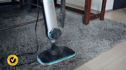 Una aspiradora con vapor en la alfombra de un salón.