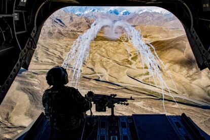 Un soldado de Estados Unidos a bordo de un helicóptero Chinook observa los test de lanzamiento durante un entrenamiento aéreo en Afganistán.