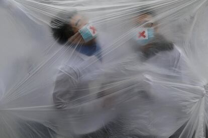 Unos estudiantes universitarios durante una performance para crear conciencia sobre la contaminación del aire en Xi an (China).