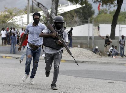 Agentes de la policía corren hacia un enfrentamiento armado con soldados del Ejército haitiano.