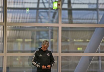 Mourinho mira su movil antes de la rueda de prensa en Schalke 04.