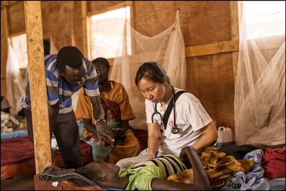 Médico escuchando a una paciente en la sala principal de la clínica de MSF en Melut.