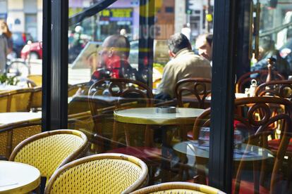 Clientes de un restaurante parisino en la terraza.