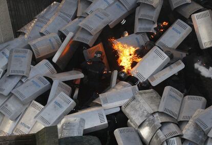 Un grupo de policías antidisturbios tratan de evitar las llamas de un cóctel molotov lanzado por los manifestantes antigubernamentales en frente del Parlamento de Ucrania en Kiev.