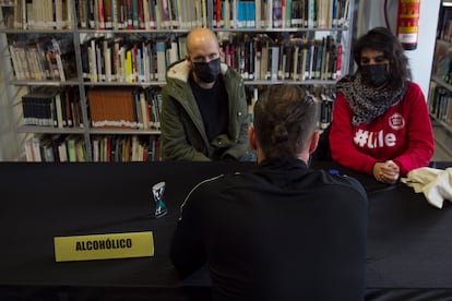 Daniel y Leticia escuchan el relato de Rubio, uno de los reclusos participantes en la iniciativa desarrollada el viernes en la biblioteca de Soto del Real (Madrid).