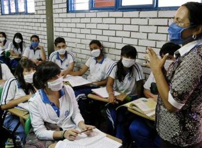 Una profesora y alumnos de un colegio de Cali (Colombia), con mascarillas durante una clase.