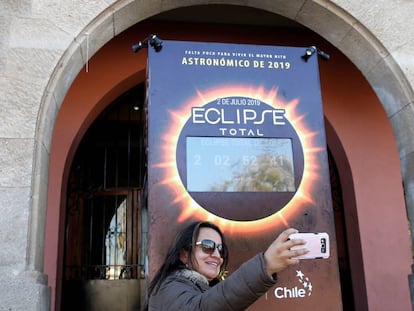 Turista faz selfie em frente a um mostrador com a contagem regressiva para o eclipse solar em Coquimbo (Chile).