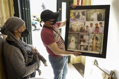 Rachid El Yagoubi y Fatima Maknassi, muestran las fotos de su boda en el portal del piso de Entrevías que han dejado en la mañana del viernes.