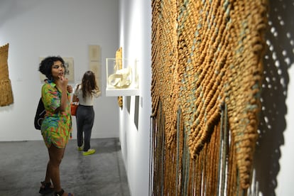 Una visitante a la feria Art Basel Miami observa las obras de la artista española Aurelia Muñoz expuestas.